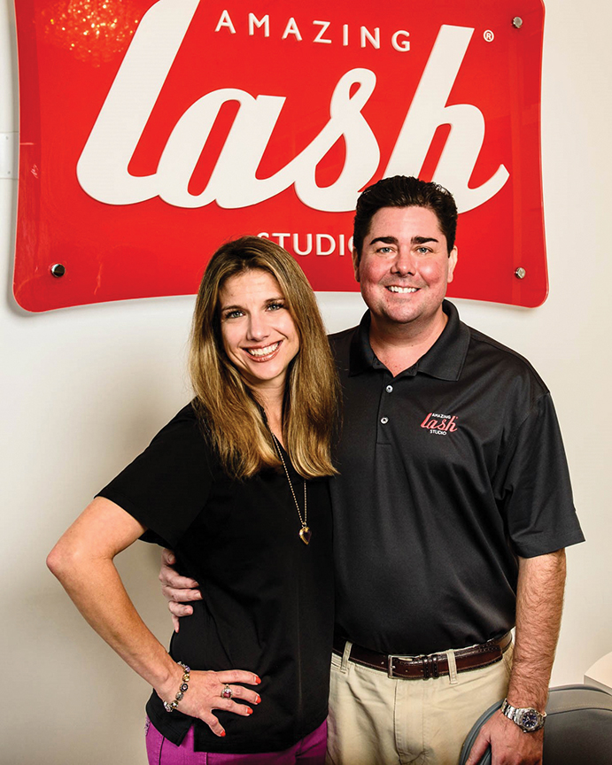 Amazing Lash Franchise owners posing in front of lash logo