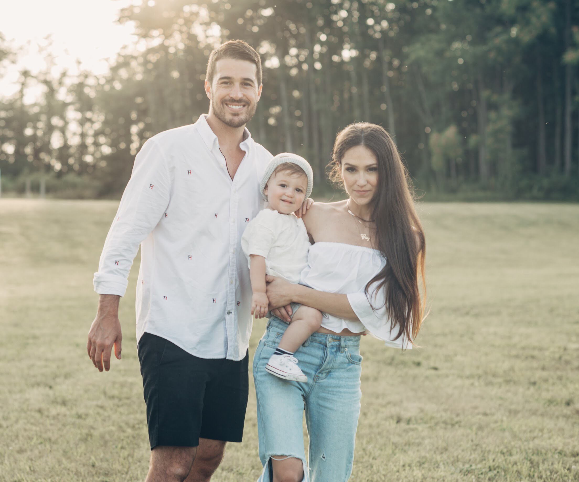 Amazing Lash Studio Owners posing in a field with their child