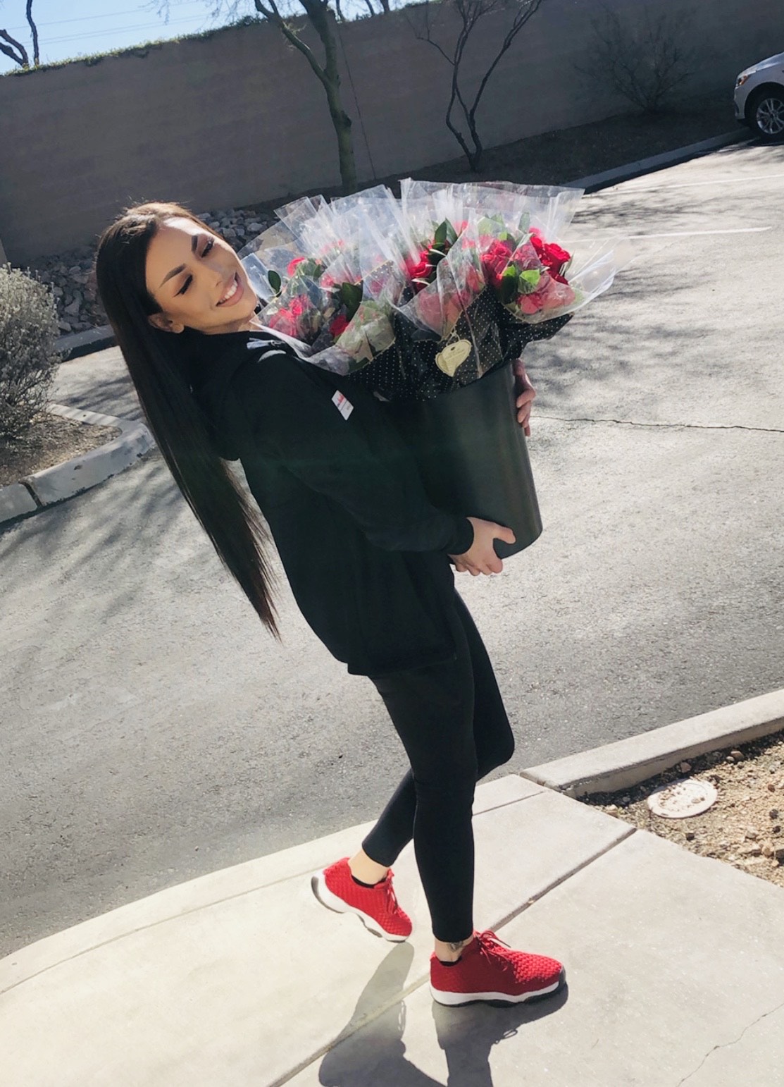 woman carrying bunches of roses